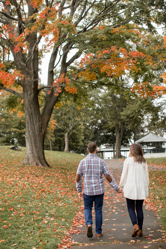 A couple takes fall engagement photos walking through Boston