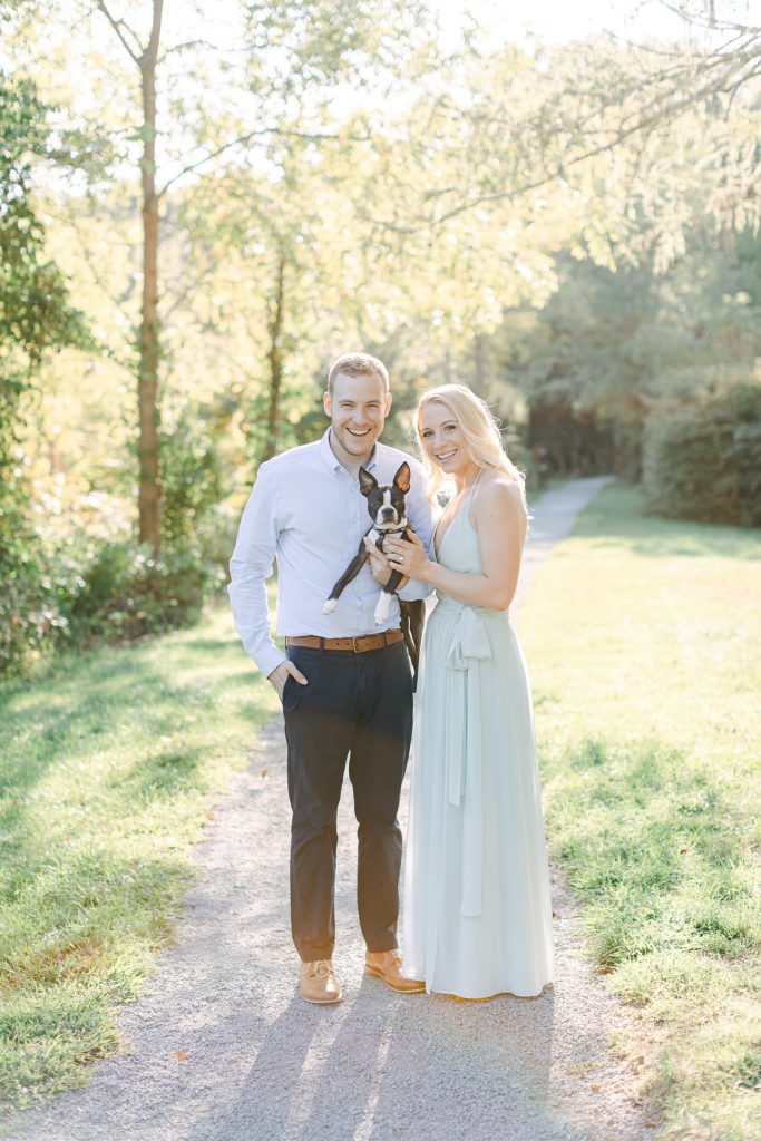 A couple poses with their dog for their engagement photos