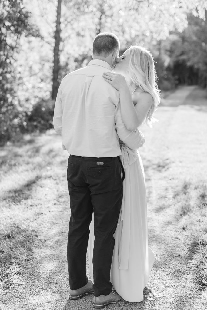 Black and white engagement photo with the woman kissing her fiance