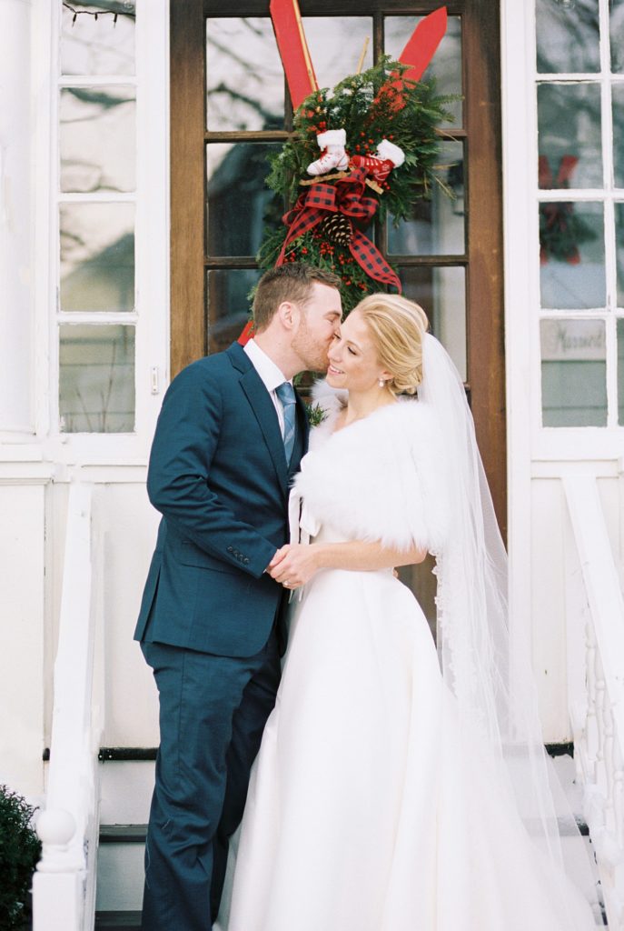 Newlyweds kiss in front of their front door
